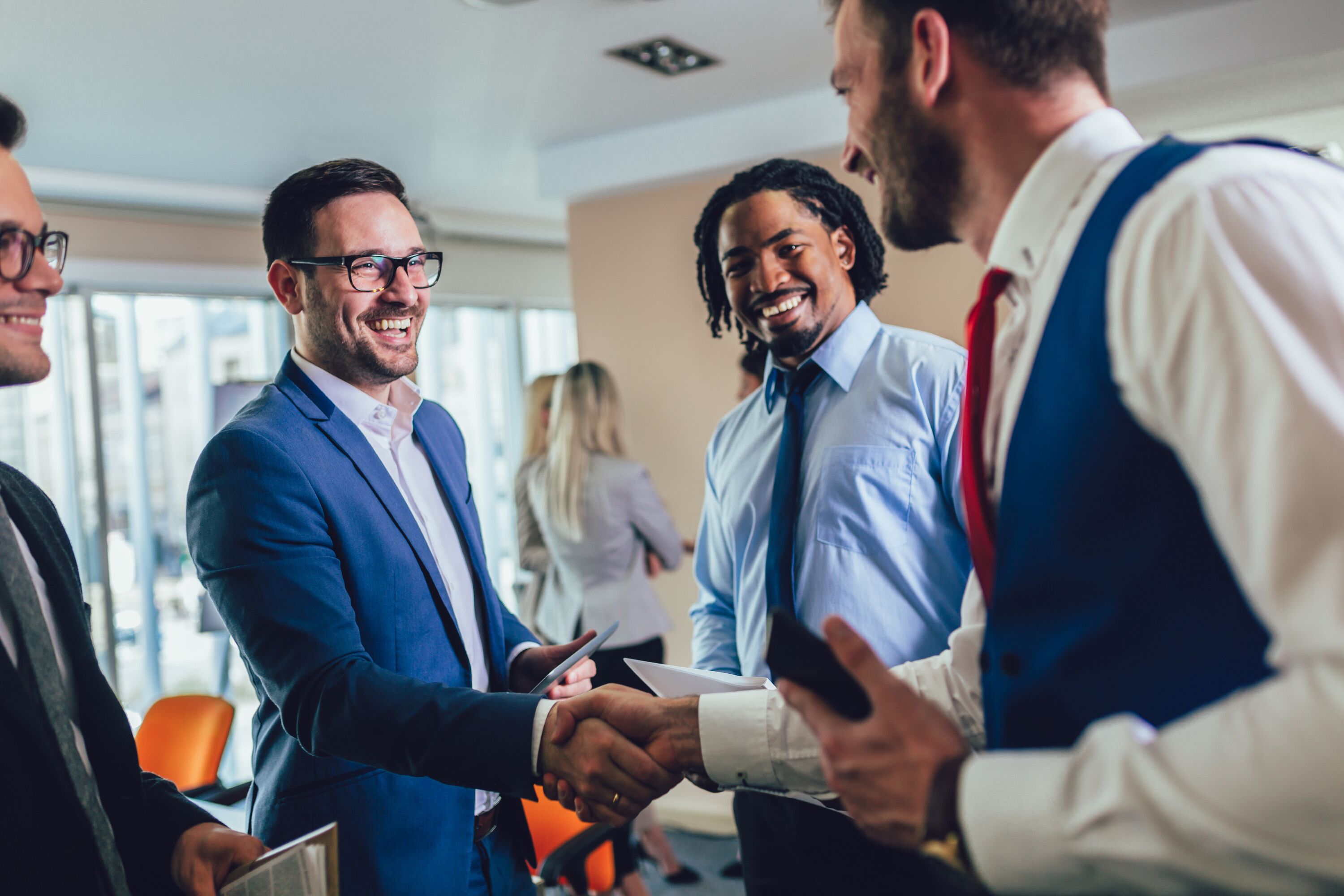 Happy businessmen handshaking after negotiation in office.