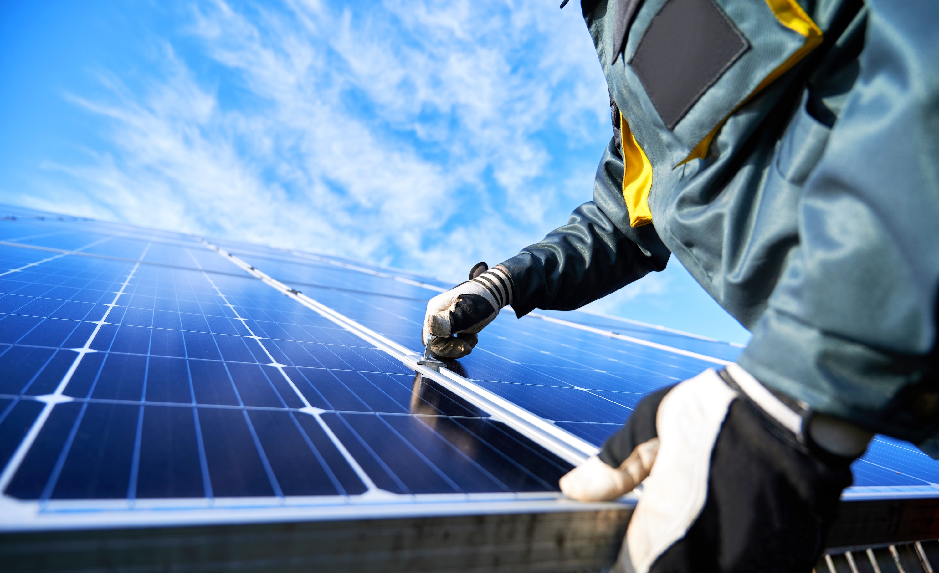 A person repairing a solar panel on a roof