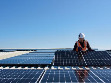 Person in a hard hat installing solar panels